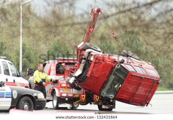 ROSEBURG, OR - MARCH 19: A tow truck lifts a car\
following a rollover accident during a spring rain in Roseburg\
Oregon, March 19,\
2013