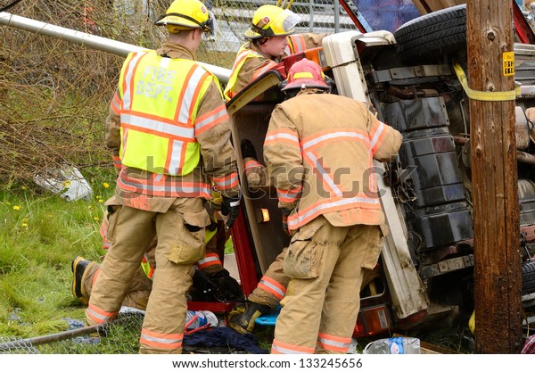 ROSEBURG, OR - MARCH 2013: Emergency workers at\
the scene of a single car, rollover accident during a spring rain\
in Roseburg Oregon, March 19,\
2013