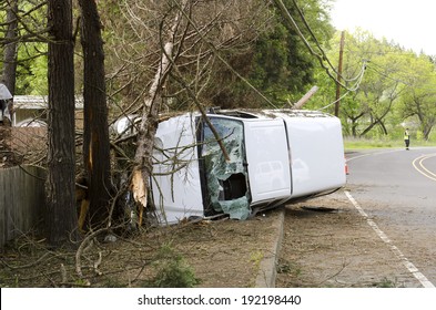 ROSEBURG, OR, USA - APRIL 25, 2014: Fire Fighters And Police At A Single Vehicle Accident That Rolled And Hit A Power Pole And Trees Resulting In Minor Injuries To The Driver.