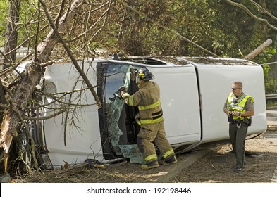 ROSEBURG, OR, USA - APRIL 25, 2014: Fire Fighters And Police At A Single Vehicle Accident That Rolled And Hit A Power Pole And Trees Resulting In Minor Injuries To The Driver.