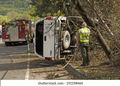 ROSEBURG, OR, USA - APRIL 25, 2014: Fire Fighters And Police At A Single Vehicle Accident That Rolled And Hit A Power Pole And Trees Resulting In Minor Injuries To The Driver.