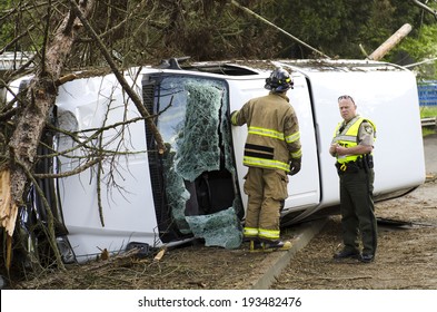 ROSEBURG, OR, USA - APRIL 25, 2014: Fire Fighters And Police At A Single Vehicle Accident That Rolled And Hit A Power Pole And Trees Resulting In Minor Injuries To The Driver.