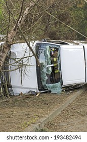 ROSEBURG, OR, USA - APRIL 25, 2014: Fire Fighters And Police At A Single Vehicle Accident That Rolled And Hit A Power Pole And Trees Resulting In Minor Injuries To The Driver.