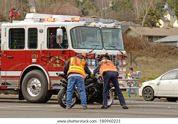 ROSEBURG, OR, USA - JANUARY 13, 2014: \
Emergency responders at the scene of a motorcycle vs car at a busy\
intersection that left the rider with serious\
injuries.
