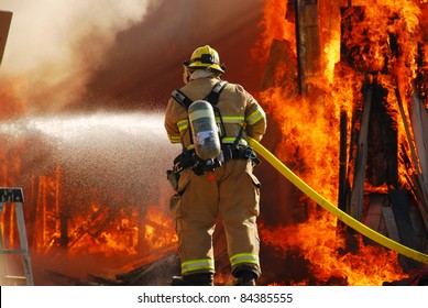 ROSEBURG, OR - SEPTEMBER 03: Single fire fighter spraying a straight steam into a fully involved shop fire off of Breezy Lane, September 03, 2011 in Roseburg, OR