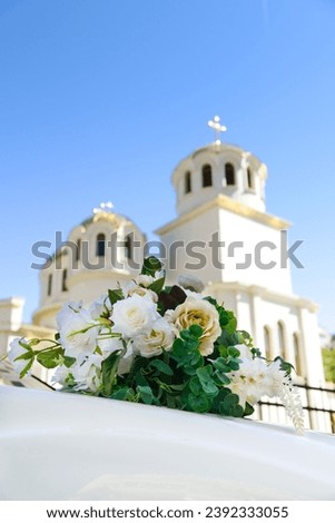A rose-decorated wedding car against the backdrop of a church's glittering gilded domes. Vertical orientation. Selective focus.