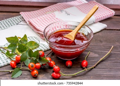 Rosehip Jam In The Bowl Of Glass With Hips And Branches On Wooden Table