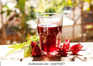 Roselle Tea Glass With Fresh Roselle Fruit On Wooden Table, Healthy Herbal Drink Concept. (karkade, Red Sorrel, Agua De Flor De Jamaica) 