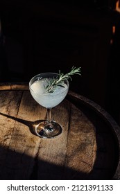 Rosemary Gin Vodka Gimlet Herbal Cocktail In Coupe Glass Atop Wooden Barrel