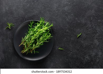 Rosemary herb on a plate on a black background.