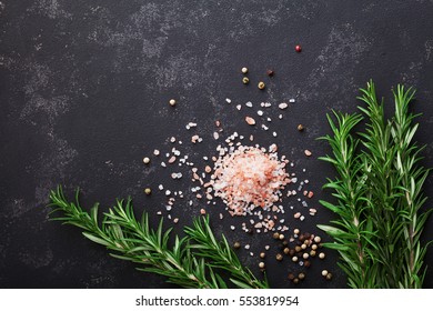 Rosemary plant, pink salt and spices on black stone table from above with copy space for menu or recipe, flat lay. - Powered by Shutterstock