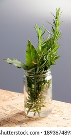 Rosemary stems and laurel leaves in crystal jar