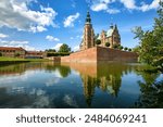 Rosenborg castle in Copenhagen city, Denmark, reflecting in a lake on a sunny summer day