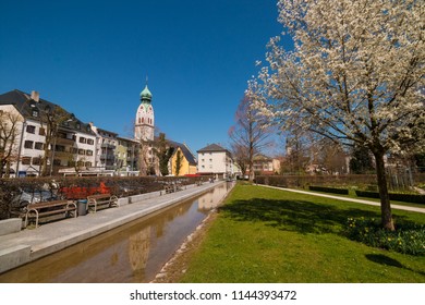 Rosenheim, Bavaria, Germany - April 8, 2018: View of Riedergarten park and St. Nikolaus church on a sunny spring day.