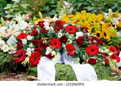 Roses, Gerbera, Lilies And Sunflowers On A Grave After A Funeral