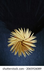 Rosette toothpicks form a dark background graphic design on the kitchen table.