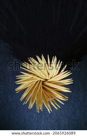 Rosette toothpicks form a dark background graphic design on the kitchen table.