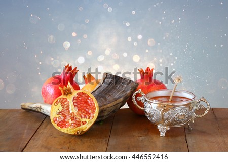 Rosh hashanah (jewish New Year holiday) concept - honey, shofar (horn) and pomegranate over wooden table. Traditional symbols