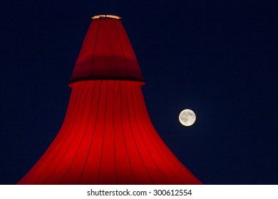 ROSKILDE, DENMARK - JULY 2 Full Moon Behind Glowing Stage Tent At Roskilde Festival 2015. Roskilde Festival Is One Of The Largest Music Festivals In Europe.