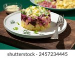 Rosolje -  Estonian beet and herring salad or Rosoli Finland salad with boiled beets, potatoes, apples, onions,  herring or other fish. Ingredients of  Scandinavian cuisine, green background
