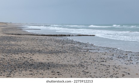 Rosslare Beach, Ireland  A rainy, wet, misty summer morning - Groynes or Groins jutting out into the sea at low tide - Powered by Shutterstock