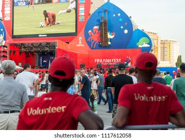 Rostov-on-don city, Russia, 16 June 2018. Two black guys football fans are watching football on a huge screen in the fan zone during the world Cup. Many other football fans around.