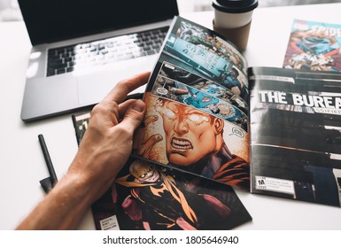 Rostov-on-Don / RUSSIA - August 27 2020 : Man Reading Comic Books On The White Table In Between Work.