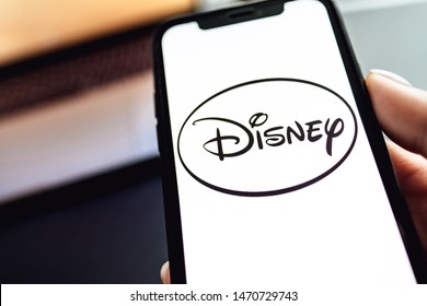 ROSTOV-ON-DON / RUSSIA - August 5 2019: Hand Holding The IPhone X With Disney Logo On The Screen. Disney Background 