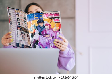 Rostov-on-Don, Russia - February 19 2021 : Young Woman Reading Chinese Manga Comic Book At Home.