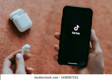 ROSTOV-ON-DON / RUSSIA - June 30 2019:
Girl holding iPhone and AirPods with TikTok logo on the screen . TikTok is app to create and share videos