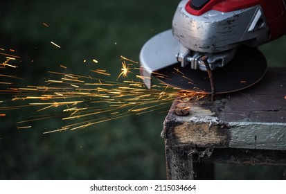 Rotary Flex Cutter Cutting Rusty Nail On Old Wooden Frame, Sparks Flying In Air, Closeup Detail