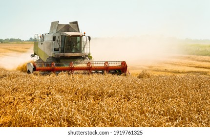 Rotary straw walker cut and threshes ripe wheat grain. Combine harvesters with grain header, wide chaff spreader reaping cereal ears. Gathering crop by agricultural machinery on field on summer season - Shutterstock ID 1919761325