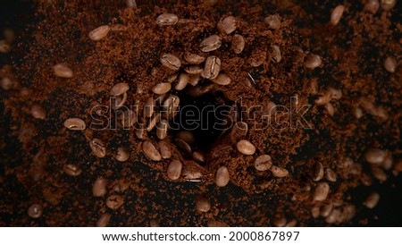 Rotating Coffee Beans in coffee grinder, Black Background.