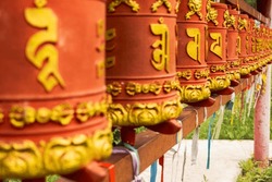Rotating Religious Elements For Touching Turning Spinning Buddhist Prayer Wheel At Buddhist Monastery. Prayer Wheels In Buddhist Stupa Temple. Buddhism Religion Concept