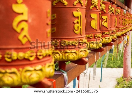 Rotating religious elements for touching turning spinning Buddhist prayer wheel at Buddhist monastery. Prayer wheels in Buddhist stupa temple. Buddhism religion concept