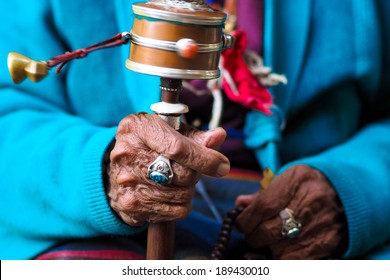 rotation buddhist prayer wheel at old woman's hand, Nepal
