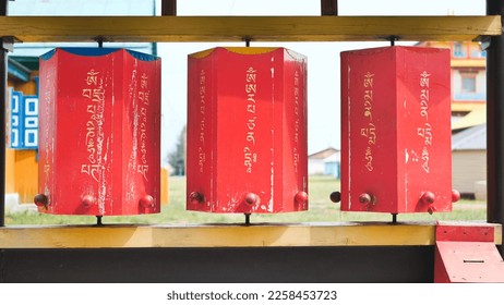 Rotation of the red prayer drums outside the Buddhist temple. - Shutterstock ID 2258453723