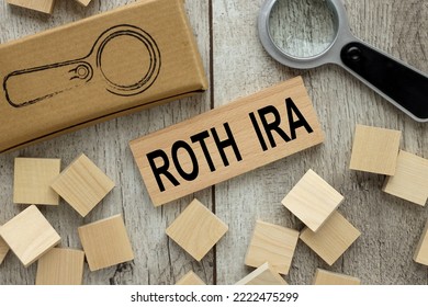 ROTH IRA wooden block on a light table. magnifier and wooden cubes. - Shutterstock ID 2222475299