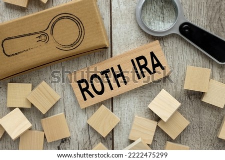 ROTH IRA wooden block on a light table. magnifier and wooden cubes.