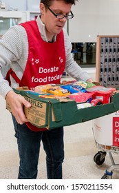 ROTHERHAM, UK – NOVEMBER 22, 2019: A Volunteer Carries A Box Of Donations At The National Food Bank Collection For Trussell Trust Foodbanks