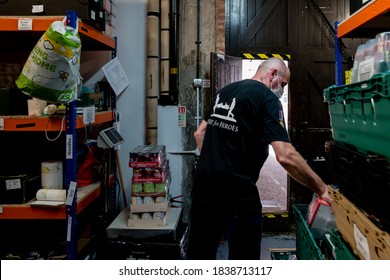 ROTHERHAM, UK - SEPTEMBER 29, 2020: A Volunteer At A Trussell Trust Food Bank Wears A Face Mask PPE In The Coronovirus Pandemic Whilst Organising Donations