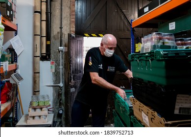 ROTHERHAM, UK - SEPTEMBER 29, 2020: A Volunteer At A Trussell Trust Food Bank Wears A Face Mask PPE In The Coronovirus Pandemic Whilst Organising Donations