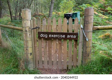 Rothiemurchus Forest, Scotland, UK, September 12 2021: Gate and sign for Dog Exercise Area with dog poo bin and forest in background. Enclosed by wooden and meshed fence.