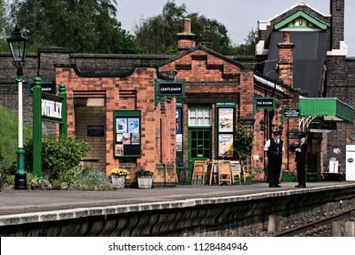 ROTHLEY Great Central  Steam Railway, UK - 2015 :  A Station Master And His Colleague Stand And Talk On The Platform Outside A Closed Cafe In A Vintage Train Station