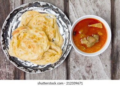 Roti Canai With Spicy Curry On Old Wood, Top View