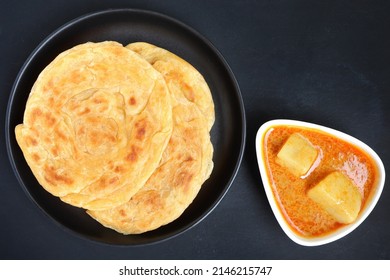 Roti Parata Or Roti Canai Served With Potato Curry Sauce On Black Background.Top View.