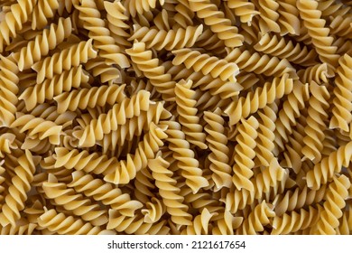 Rotini. Raw fusilli with oats background. Abstract texture of pasta. Pattern of spiral macaroni. Warm food backdrop. Uncooked noodles. Healthy eating and dietary. Soft focus - Powered by Shutterstock