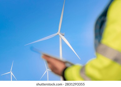 The rotor is centred and clean while everything nearer the lens melts away, a quiet composition that puts the generating machine first and the human gesture second.