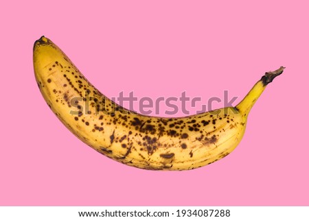 Rotten banana isolated on pink background. Expired fruit.