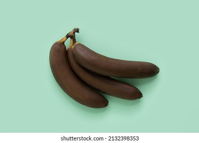 Rotten bananas on a mint green background. Darkened tropical fruit. Minimal composition of black bananas. - Shutterstock ID 2132398353